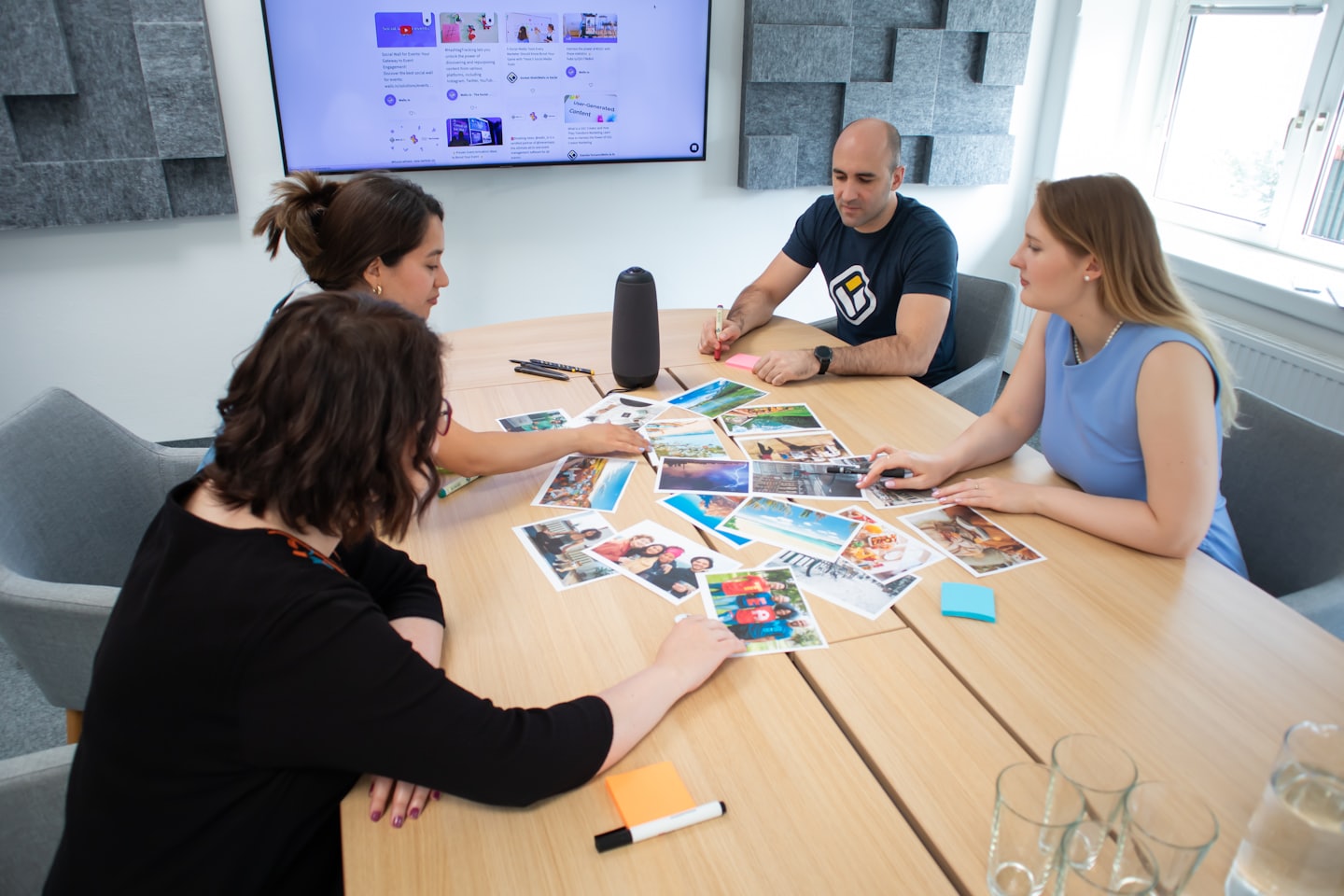 Professionisti che fanno brainstorming con fotografie stampate a un tavolo da riunione.